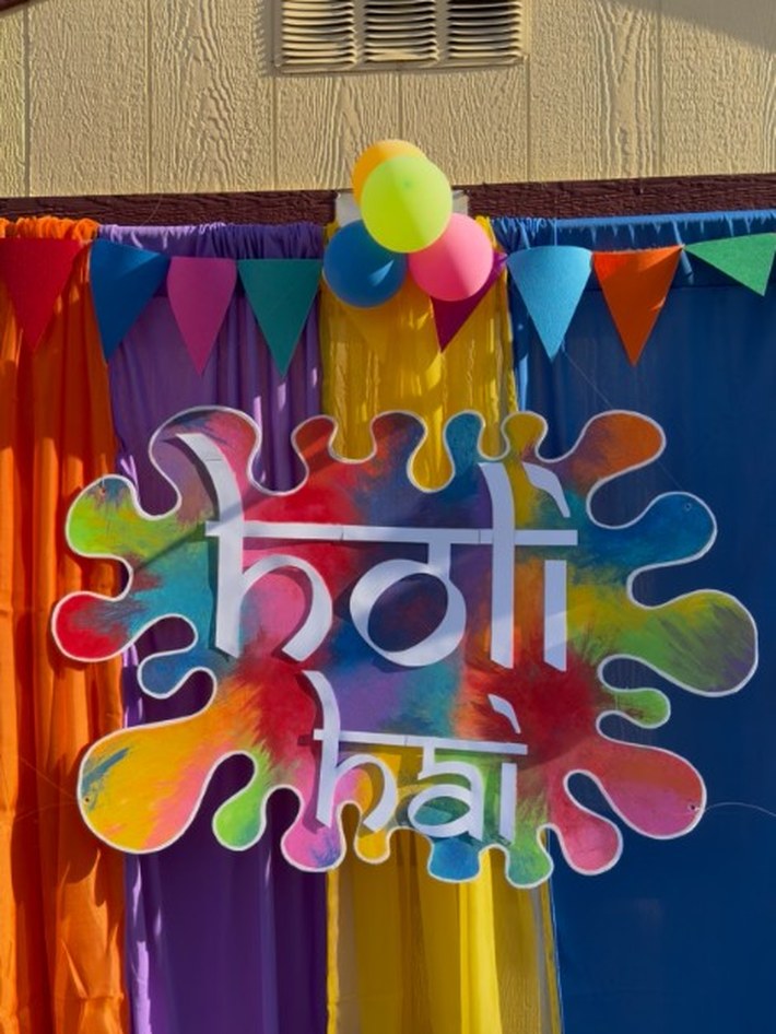 Holi Hai sign and colorful fabric drapes